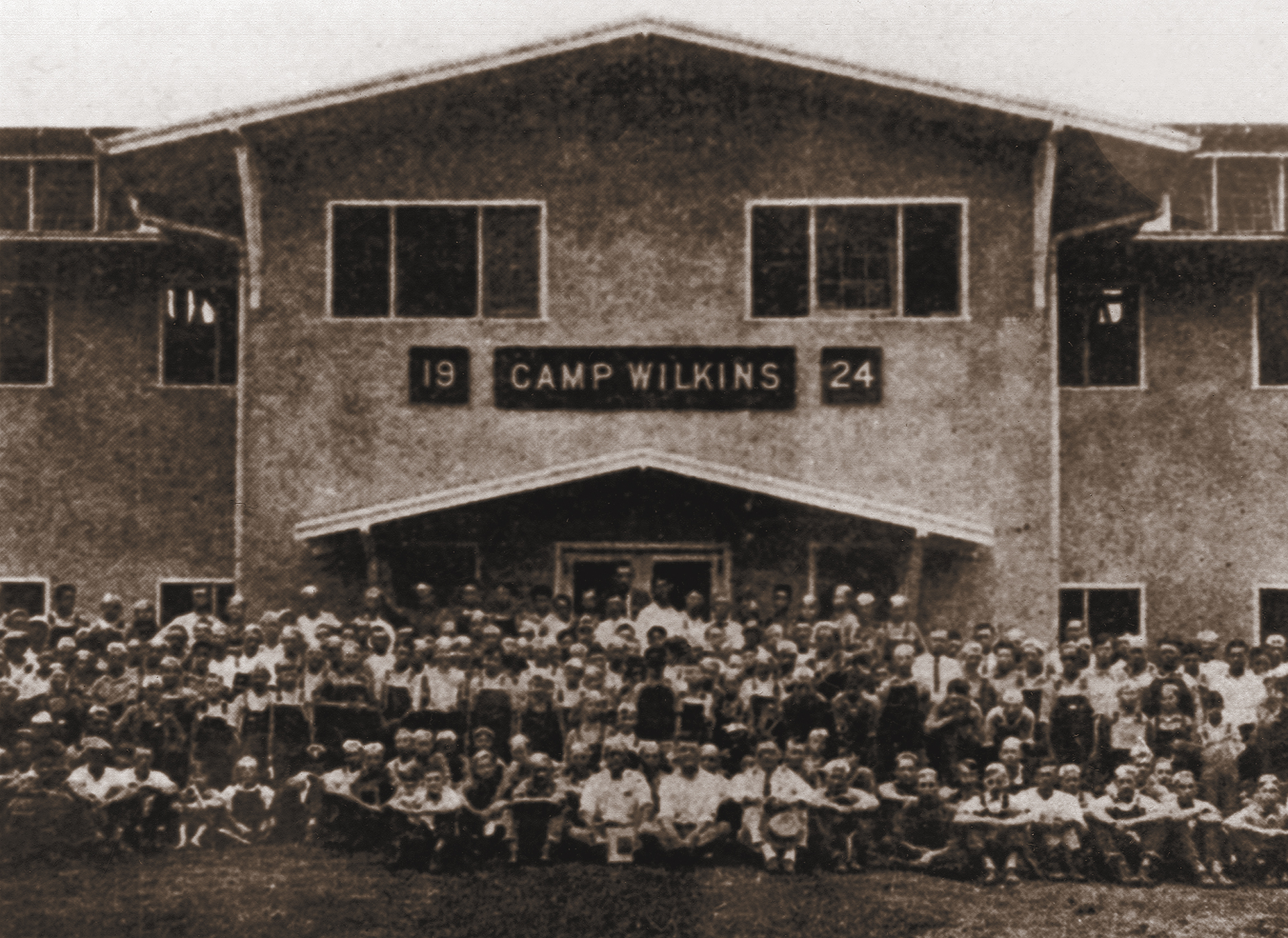 Group photo of Camp Wilkins 4-H campers sitting in front of the building
